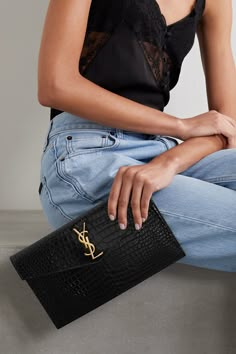 SAINT LAURENT's 'Uptown' pouch fits everything you need for an evening at a gallery opening or rooftop bar. It's been made in Italy from croc-effect patent-leather and decorated with the iconic 'YSL' hardware in gold. Carry it in hand or slip it inside one of the brand's bags. Clutch Outfit, Ysl Clutch, Gallery Opening, Black Leather Clutch, Saint Laurent Bags, Black Leather Tote, Rooftop Bar, Saint Laurent Bag, Branded Bags