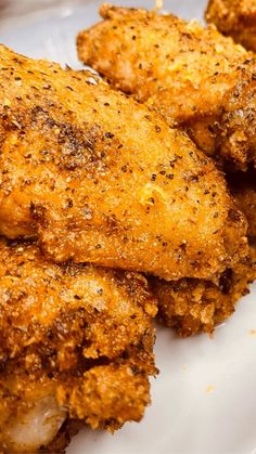 some fried chicken on a white plate with seasoning