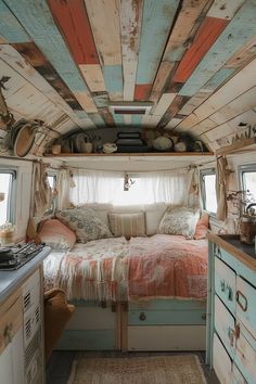 an old camper has been decorated with wood planks and colorful paint on the ceiling