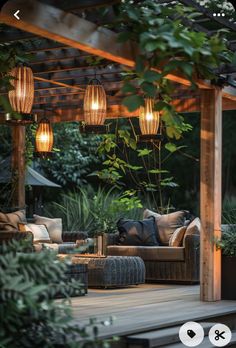 an outdoor living area with couches, tables and lights