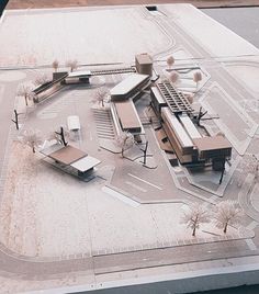 an architectural model of a building on top of a parking lot with trees and buildings