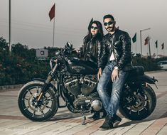 a man and woman sitting on a motorcycle