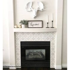 the fireplace is decorated with white and black decor, including antlers on the mantle