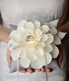 a woman holding a white flower in her hands