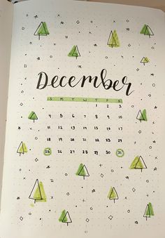 an open notebook with the words december written in black and green ink on top of it