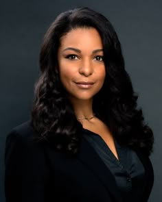 a woman in a black suit posing for a photo