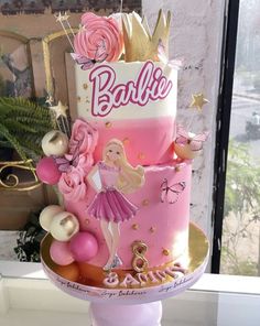 a pink and gold birthday cake with barbie on top