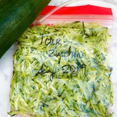 a cucumber is sitting on top of a plastic bag with writing on it