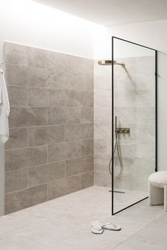 a bathroom with a walk in shower next to a bench