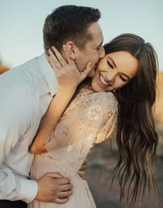 a man and woman embracing each other in the desert