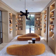 a living room filled with lots of furniture and bookshelves next to each other