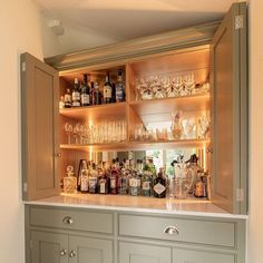 a bar with lots of liquor bottles and glasses on the top shelf in front of it