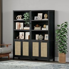 a black bookcase with wicker baskets in front of it and a potted plant next to it