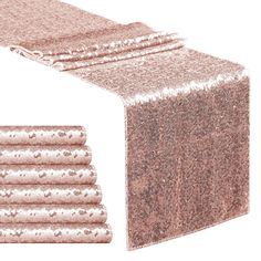 a pink table runner with sequins on it and four napkins in the middle