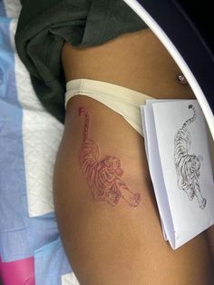 a woman's stomach with a tiger tattoo on it, next to an envelope