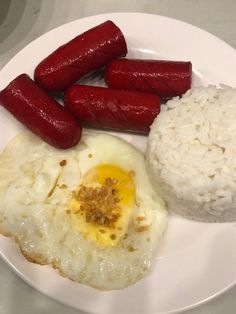 a plate with rice, sausage and eggs on it