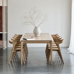 a white vase sitting on top of a wooden table