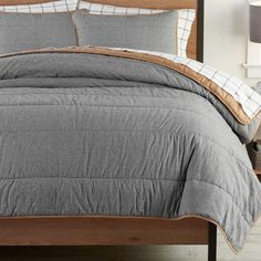 the comforter is neatly made and ready for someone to use in their bed room