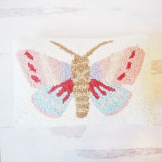 an embroidered pillow with a butterfly on it