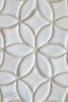 a close up view of a white tile with wavy lines and circles in the center