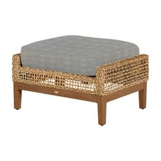 the ottoman is made out of wicker and has a white cushion on top of it