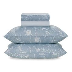 three pillows stacked on top of each other with blue and white floral designs in them