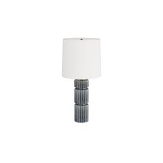 a lamp that is on top of a white surface with a light shade over it