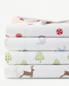 four sheets are stacked on top of each other with christmas trees and deers printed on them