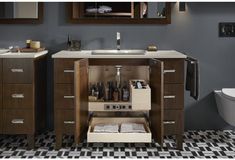 a bathroom with two sinks and a cabinet in the middle that has bottles on it