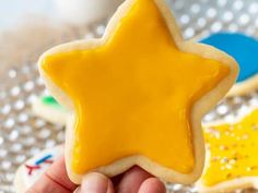 a hand holding a yellow star shaped cookie