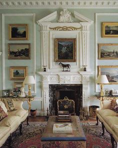 a living room filled with furniture and paintings on the wall above it's fireplace