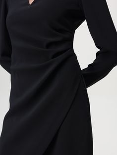 This dress is a classic design. It has a V-neck, long sleeves and a knee length. The dress is made from a stretch fabric and has a back zip closure. Black Long Sleeve Dress, Knee Length Skirt, Woman Colour, Sleeve Dress, Black Color, Knee Length, Wrap Dress, Black Dress, Long Sleeve Dress