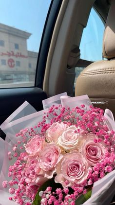 a bouquet of pink roses in the back seat of a car