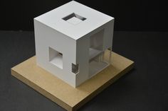 a small white house sitting on top of a piece of cardboard