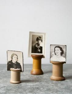 three miniature photos are placed on top of a wooden stand