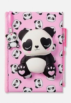 a pink notebook with pandas on it and a pen in the front, sitting next to an eraser