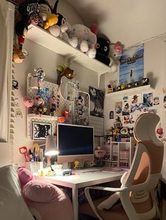 a desk with a computer on top of it next to a chair and other items