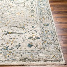 an area rug on the floor with wooden floors and hard wood planks in the background