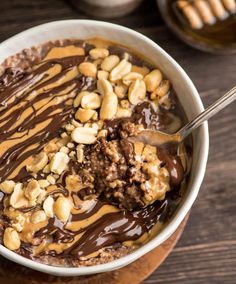 a bowl filled with chocolate and nuts on top of a wooden table