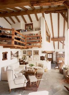 a living room filled with furniture and lots of wooden beamed ceiling beams in an old building