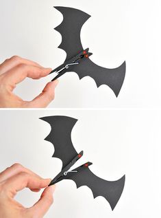 someone cutting out the shape of a bat with scissors