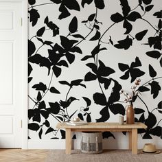 black and white floral wallpaper in an entryway with a bench next to it