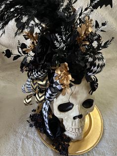 a white skull with black and gold decorations on it's head sitting on a plate