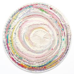 a multicolored round rug on a white background