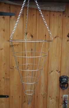 a metal basket hanging from the side of a wooden wall