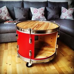 a living room with a couch and a red drum case on top of the coffee table