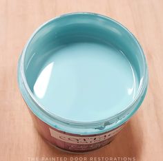 a blue paint can sitting on top of a wooden table