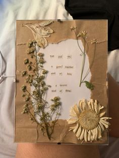 a hand holding a piece of paper with flowers on it and a poem written in the middle