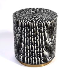 a black and white patterned stool with gold trim