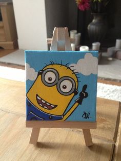 a minion painting on an easel sitting on a table